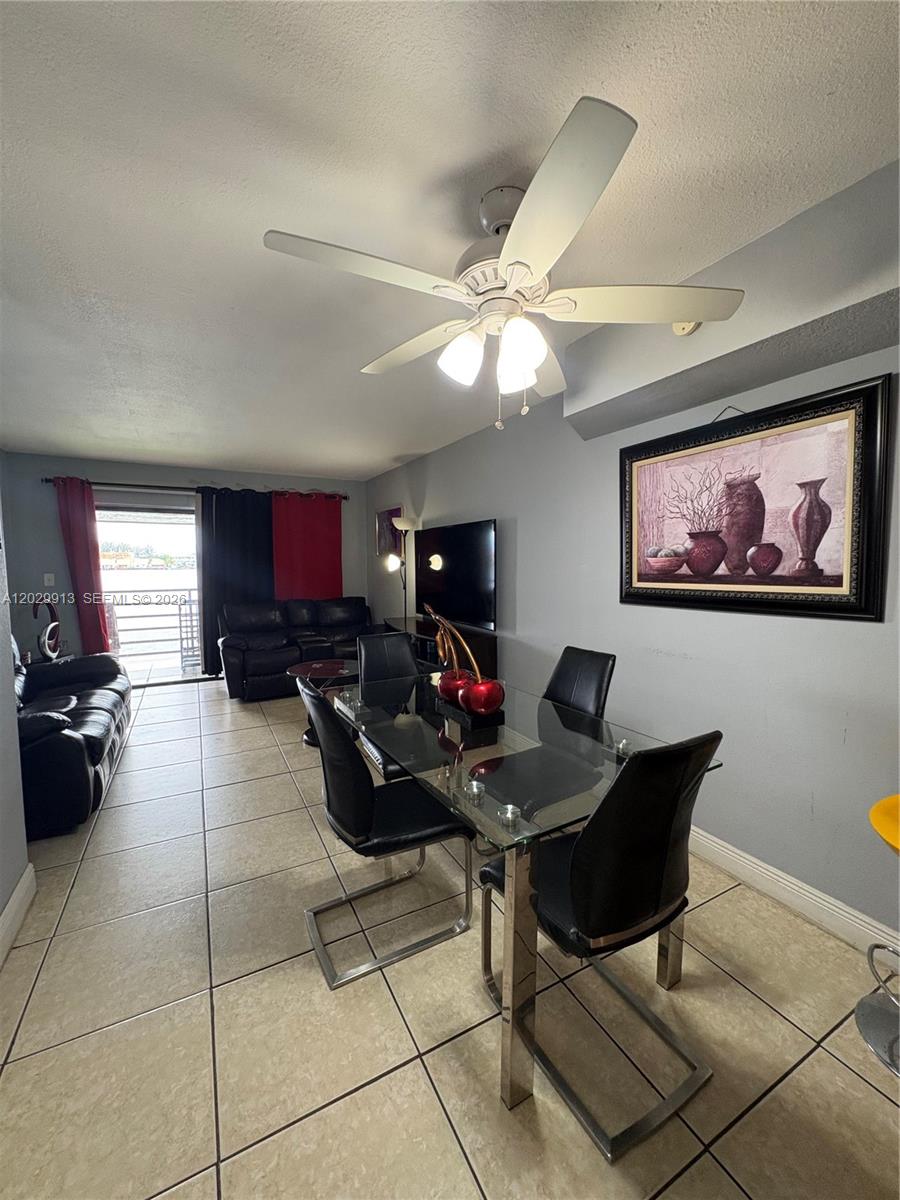 A dining area with a glass table and black chairs sits before a living room — 2778 W 60th St # 45, Hialeah FL 33016, HIALEAH, FL