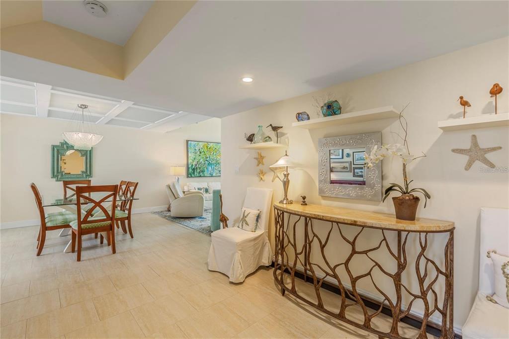 A dining area and entryway feature tile floors, a console table, and coastal-themed wall decor — 440 S GULFVIEW BOULEVARD UNIT 1705, CLEARWATER BEACH, FL