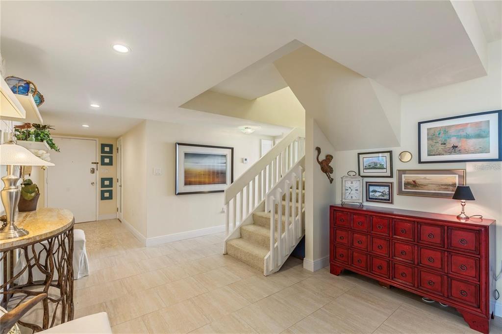 An entryway features a staircase, a red cabinet, and light-colored tile flooring — 440 S GULFVIEW BOULEVARD UNIT 1705, CLEARWATER BEACH, FL