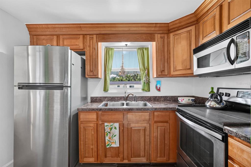 A kitchen with wood cabinets, stainless steel appliances, and a window above the sink — 277 DEBARY DRIVE, DEBARY, FL