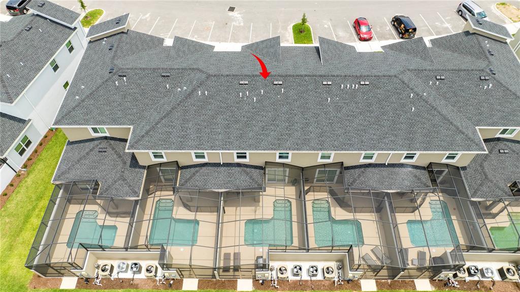An aerial view shows the shingled roof and screened-in back patios of a townhome complex — 4399 SCENE LANE, KISSIMMEE, FL