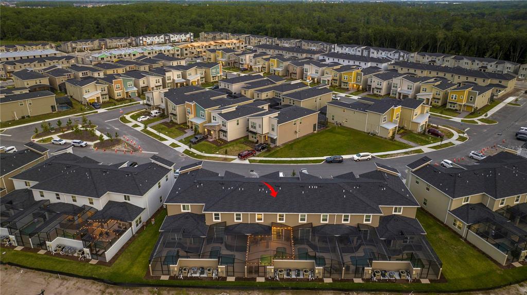 An aerial view shows a multi-unit townhouse complex with screened-in pools and a red arrow — 4399 SCENE LANE, KISSIMMEE, FL