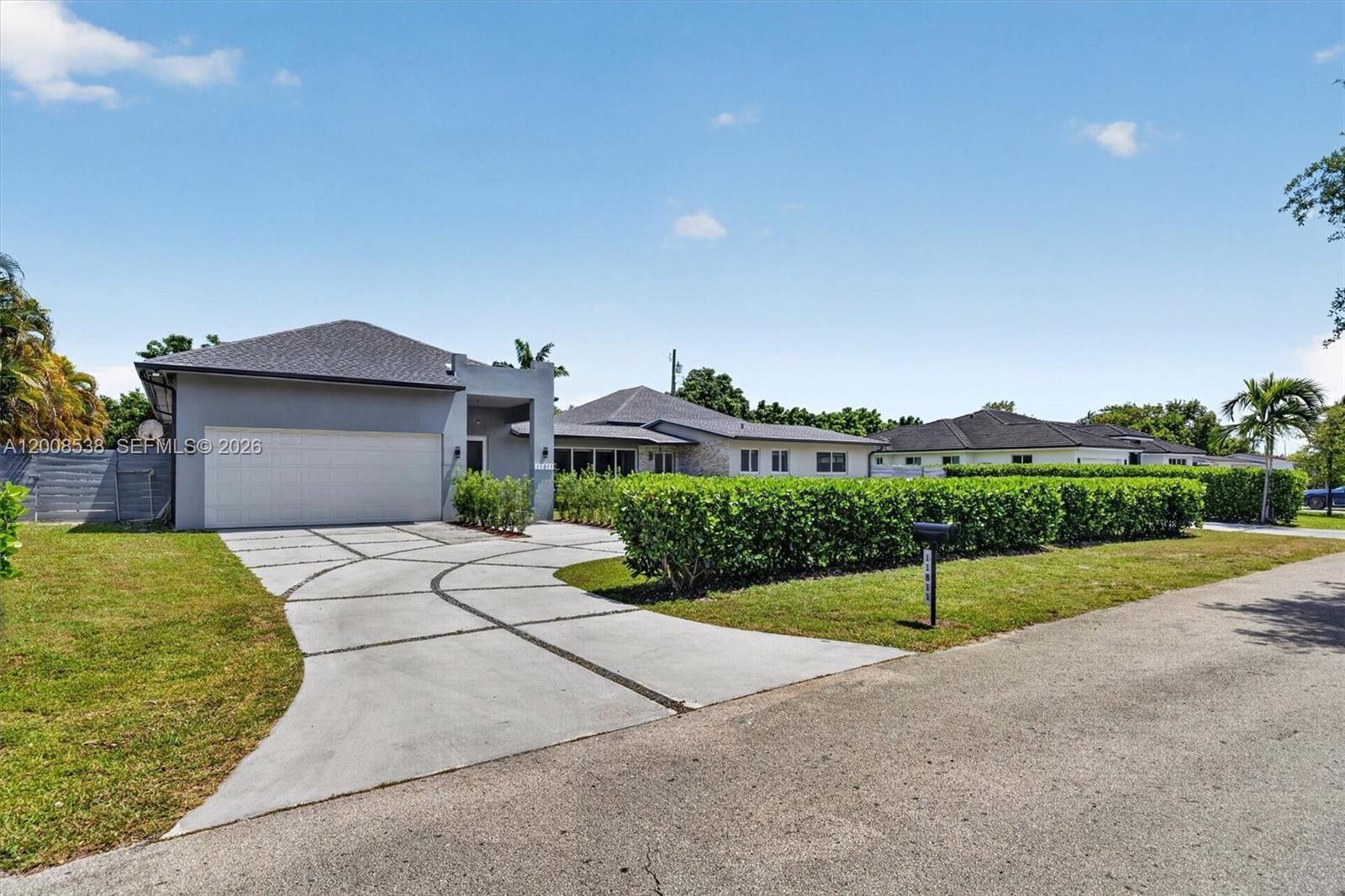 A gray house with a curved concrete driveway and a manicured hedge in the front yard — 11811 SW 82nd Rd, Miami FL 33156, MIAMI, FL