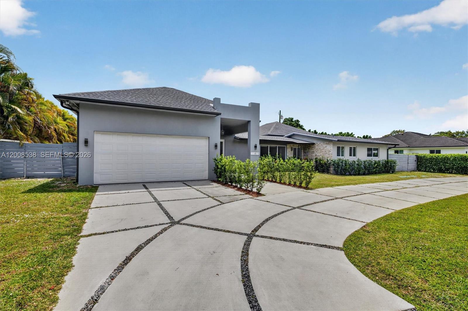 A single-story house with a gray exterior, a two-car garage, and a curved concrete driveway — 11811 SW 82nd Rd, Miami FL 33156, MIAMI, FL