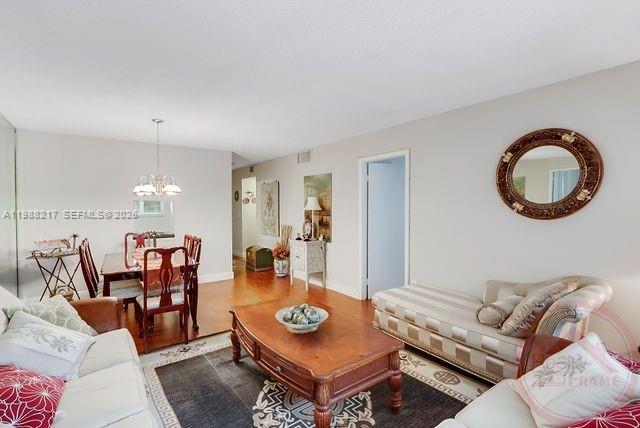 A living room features a wooden coffee table, a chaise lounge, and a dining area — 7703 Camino Real # A105, Miami FL 33143, MIAMI, FL
