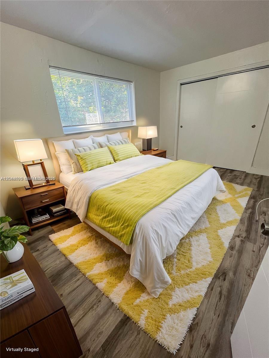 A bedroom features a bed with yellow bedding, a patterned rug, and wood-look flooring — 1630 NW 18th St # 3, Miami FL 33125, MIAMI, FL