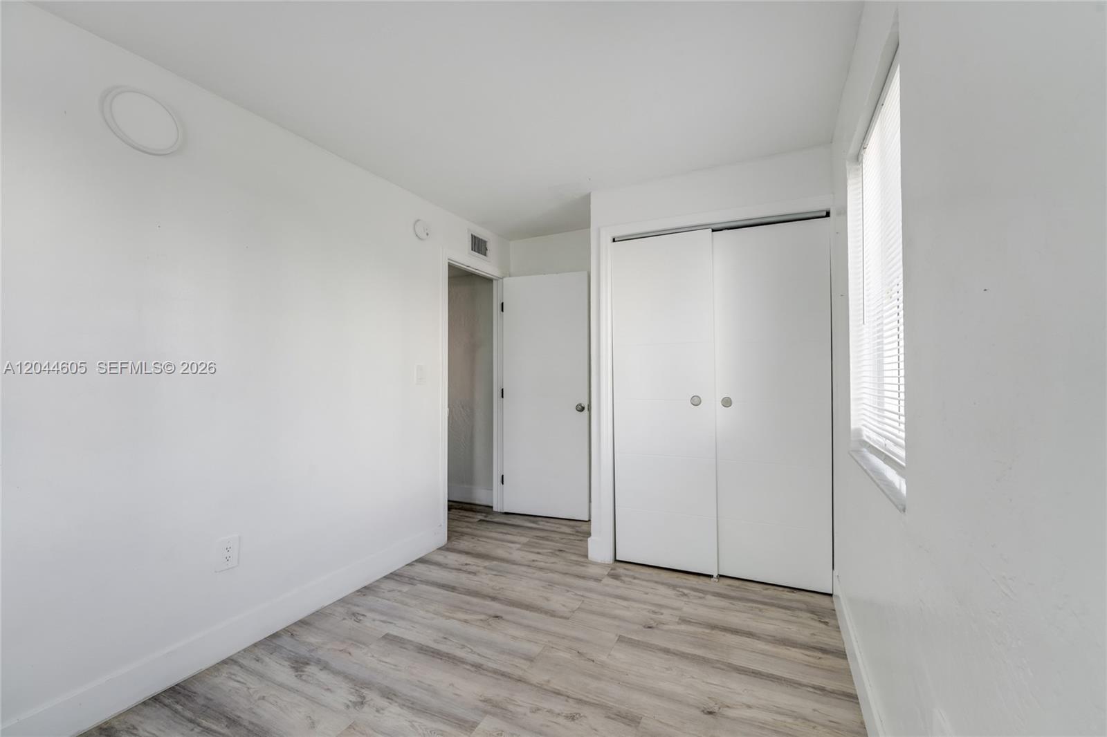 A small room features white walls, light wood-look flooring, a closet, and a window — 1630 NW 18th St # 3, Miami FL 33125, MIAMI, FL