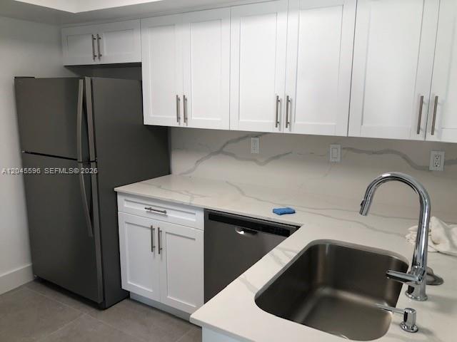 A kitchen features white cabinets, stainless steel appliances, and a white marble-patterned countertop — 9124 SW 112 CT, Miami FL 33176, MIAMI, FL