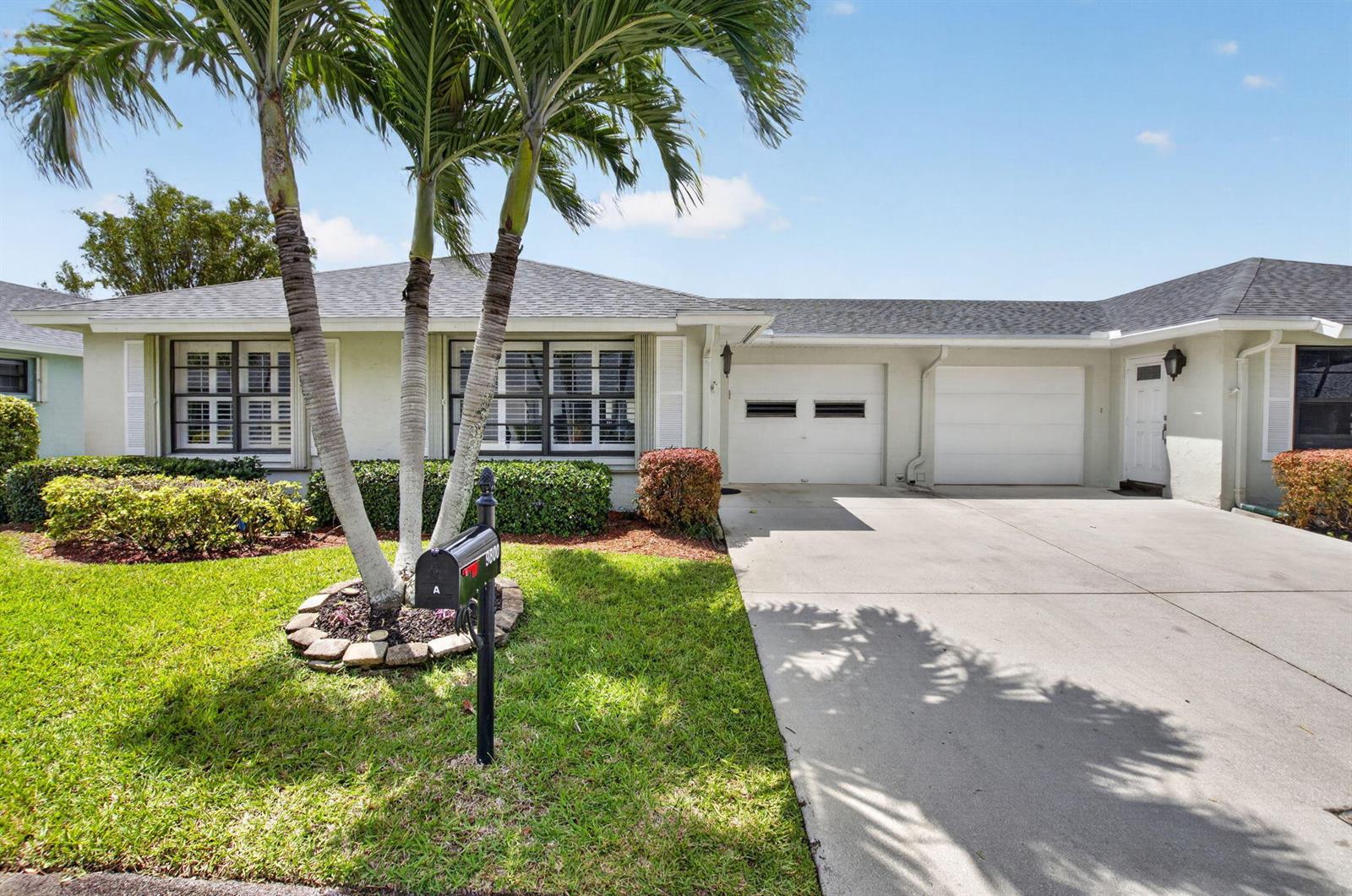 A single-story house with a two-car garage, palm trees, and a concrete driveway — 9800 Tabebuia Tree Drive # A, Boynton Beach FL 33436, BOYNTON BEACH, FL