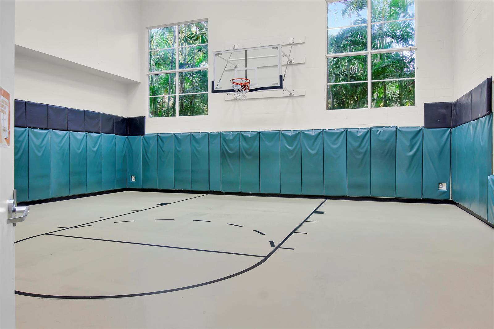 An indoor basketball court features padded teal walls, a hoop, and large windows with greenery — 1660 Renaissance Commons Boulevard # 2118, Boynton Beach FL 33426, BOYNTON BEACH, FL
