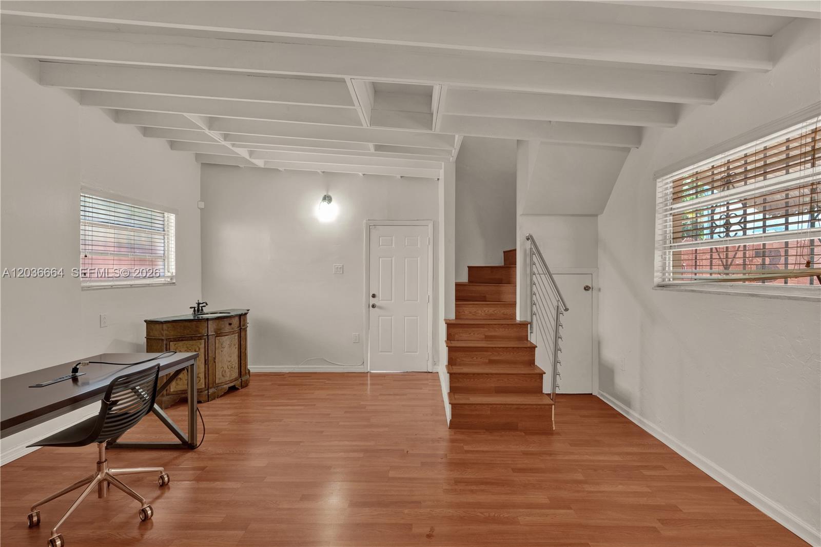 This room features wood-look flooring, exposed ceiling beams, a staircase, and two windows — 2145 SW 7th St # 2, Miami FL 33135, MIAMI, FL