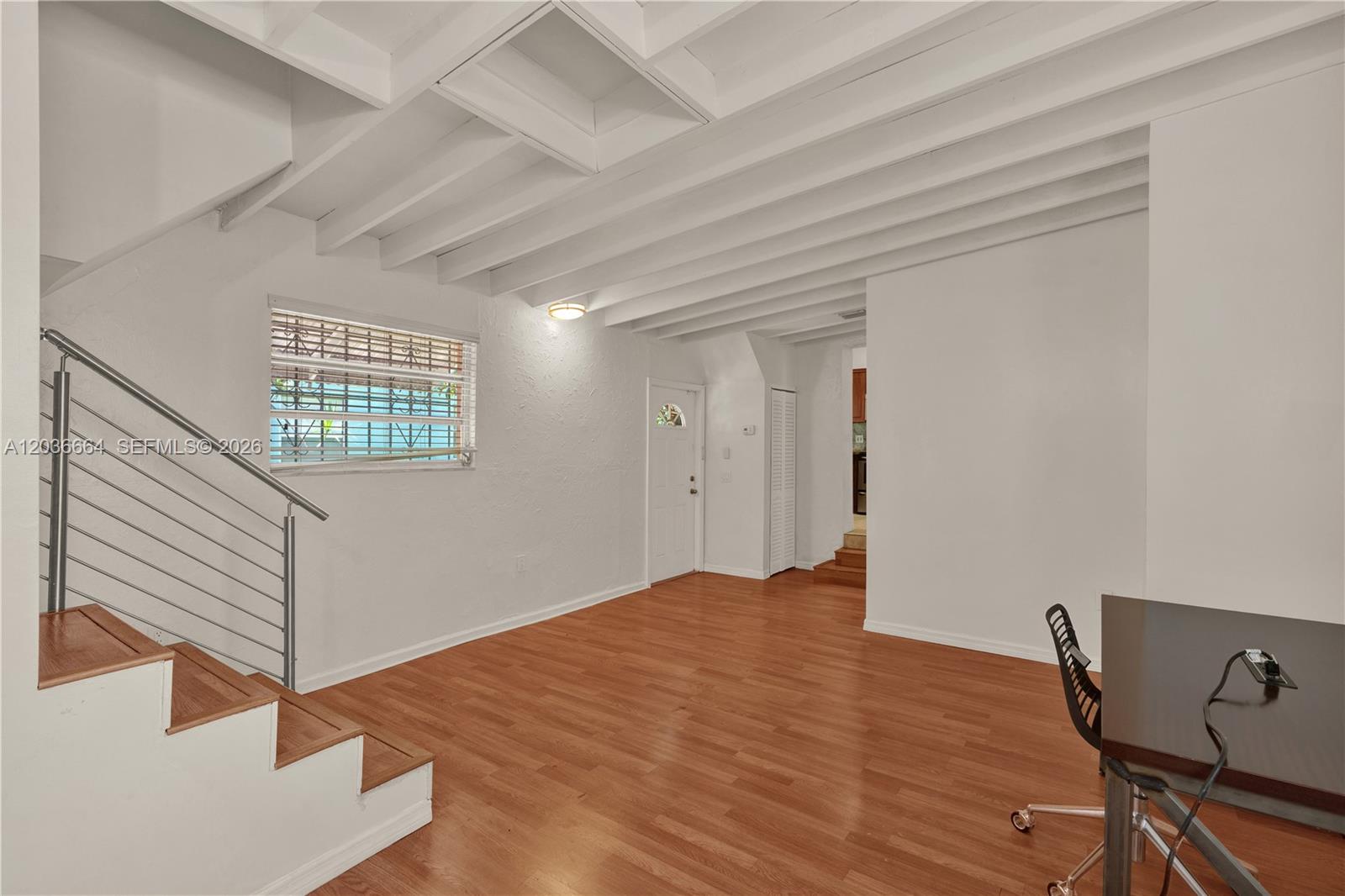 A living area features white exposed beam ceilings, wood flooring, and a staircase with railings — 2145 SW 7th St # 2, Miami FL 33135, MIAMI, FL