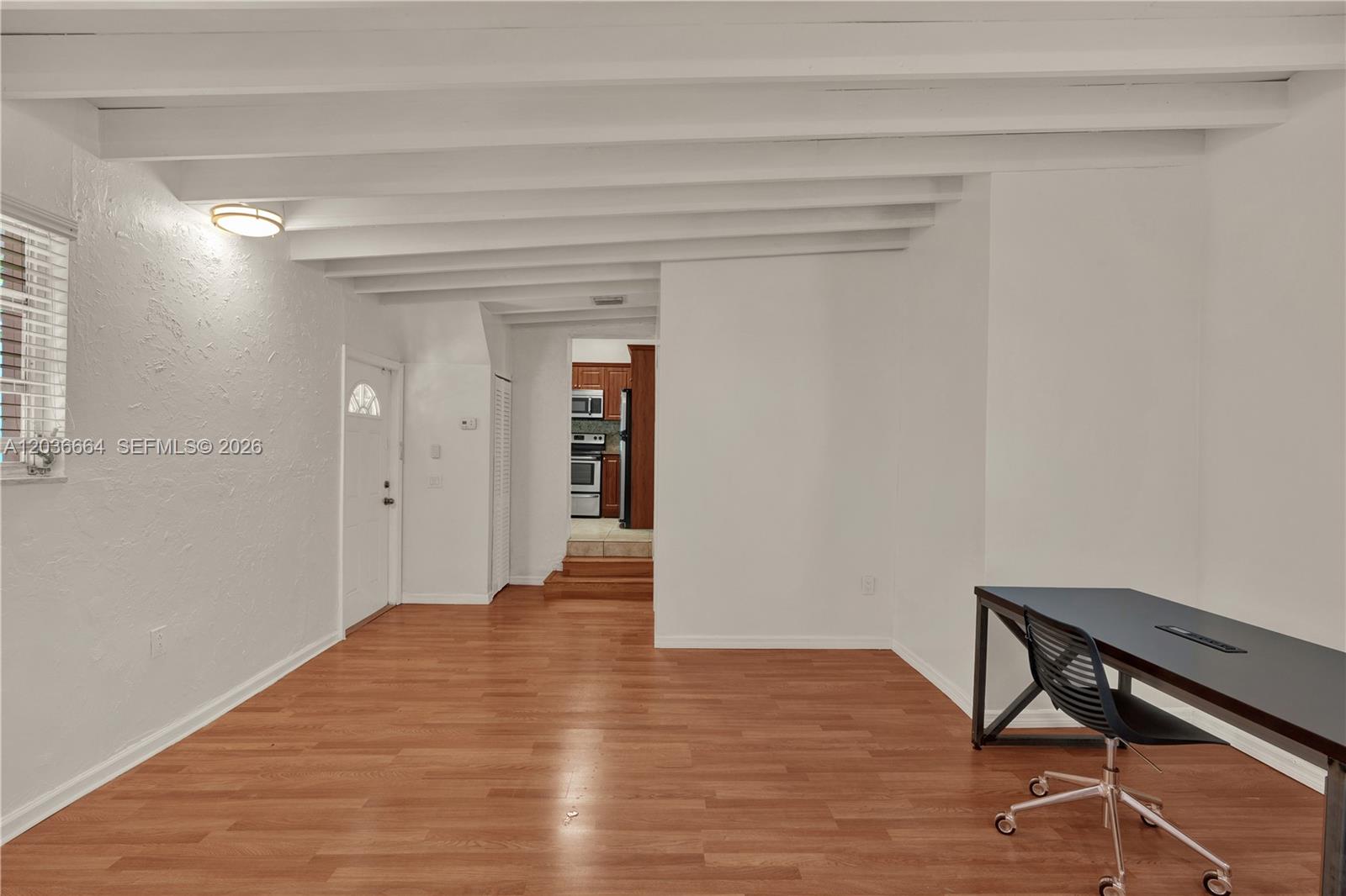 A room with white walls, exposed ceiling beams, wood flooring, and a desk — 2145 SW 7th St # 2, Miami FL 33135, MIAMI, FL