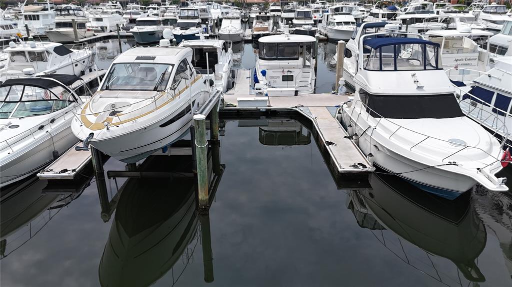 A marina filled with numerous white motorboats docked in calm water under a cloudy sky — 102 RIVIERA DUNES WAY UNIT N-14, PALMETTO, FL