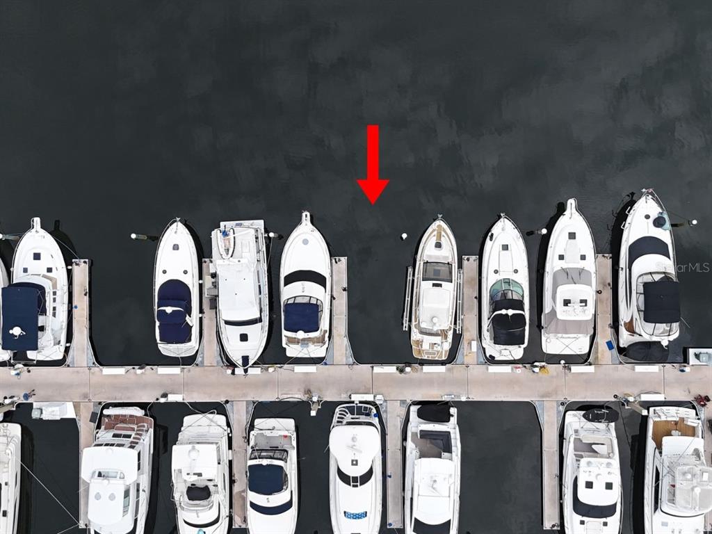 An aerial view shows several boats docked in slips along a concrete pier — 102 RIVIERA DUNES WAY UNIT N-14, PALMETTO, FL