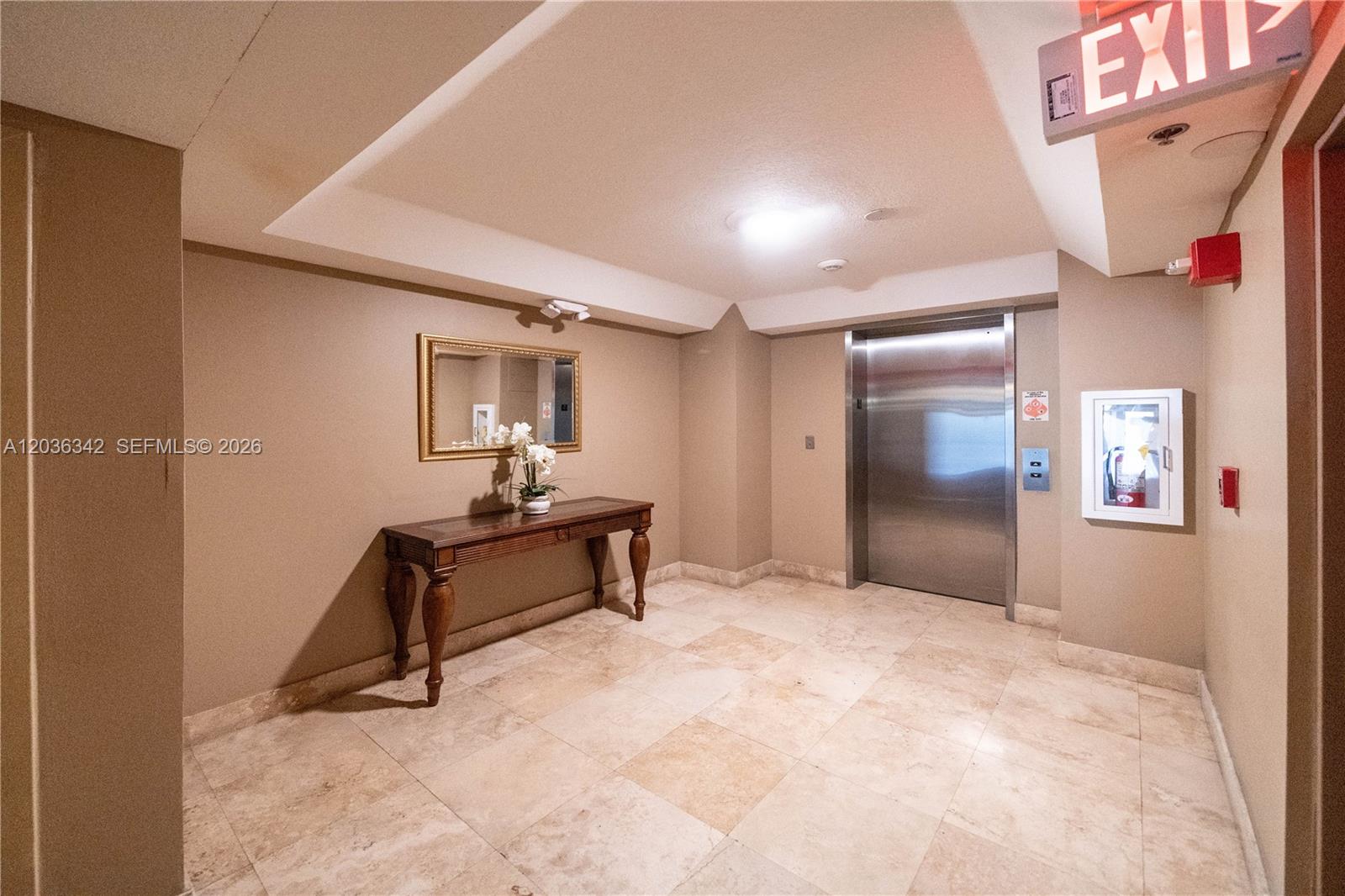 An elevator lobby features a console table, a mirror, and tiled flooring — 1650 Coral Way # 507, Miami FL 33145, MIAMI, FL