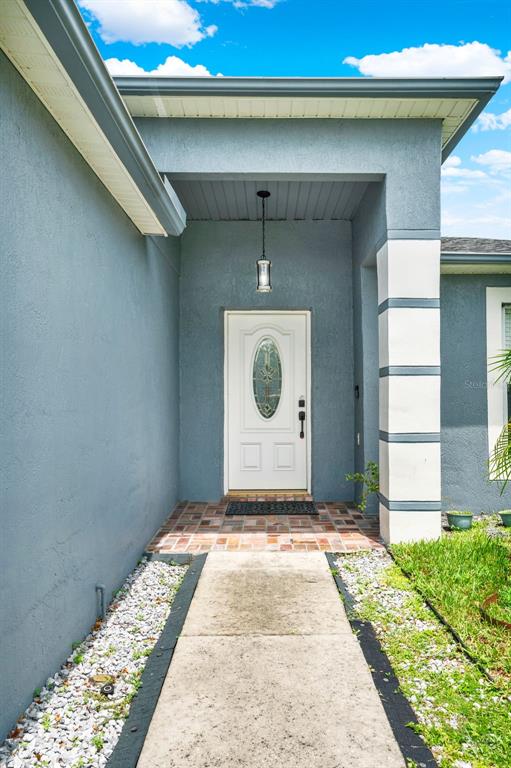The exterior view shows a blue stucco house with a white front door and walkway — 10707 PALAISEAU COURT, ORLANDO, FL