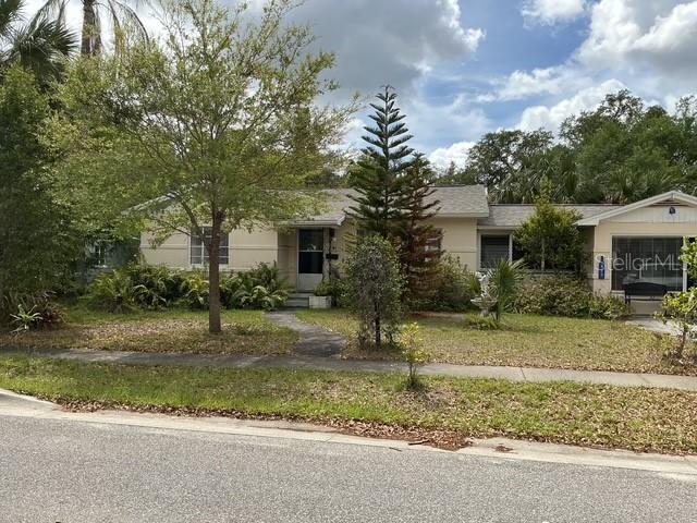 A single-story house with a light-colored exterior, a front walkway, and various trees and shrubs — 210 ALPINE DRIVE, MAITLAND, FL
