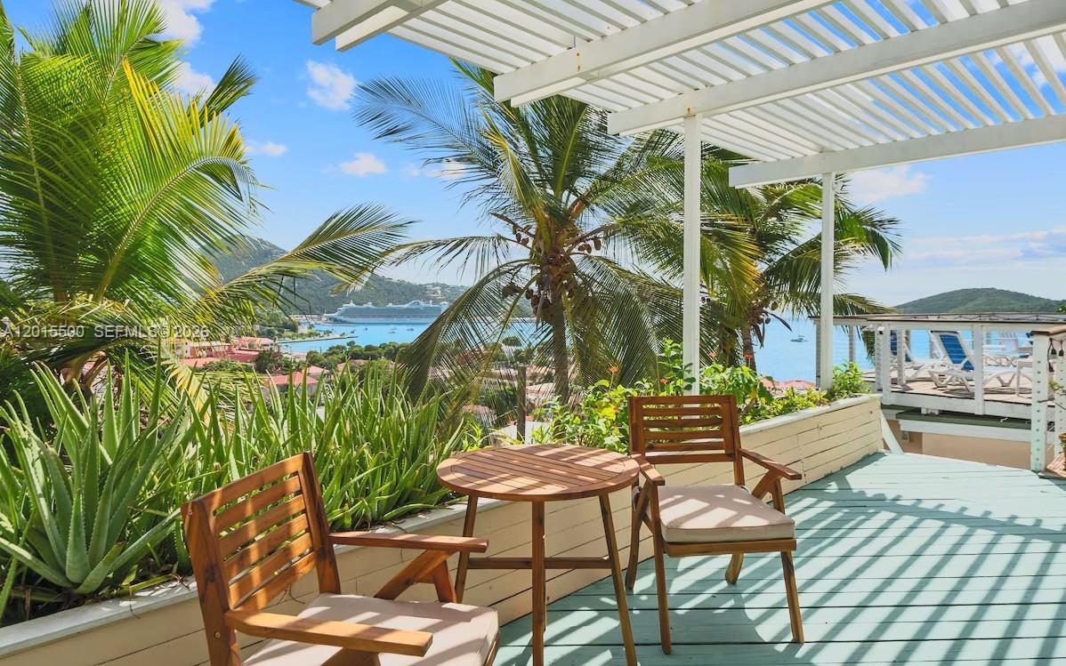 A wooden patio set sits on a deck overlooking a tropical bay with a cruise ship — 12 Murphy Gade, VI 00802, VI