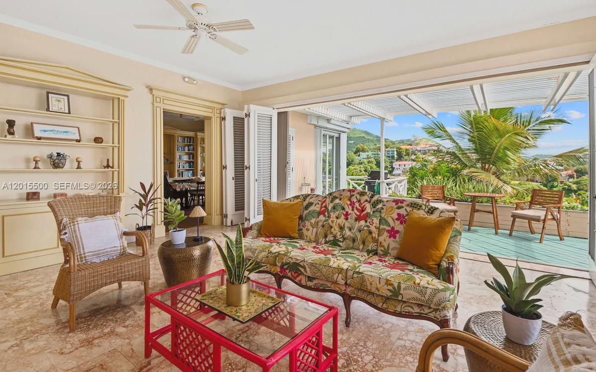 A living room features a floral sofa, wicker chairs, a pink table, and a balcony view — 12 Murphy Gade, VI 00802, VI