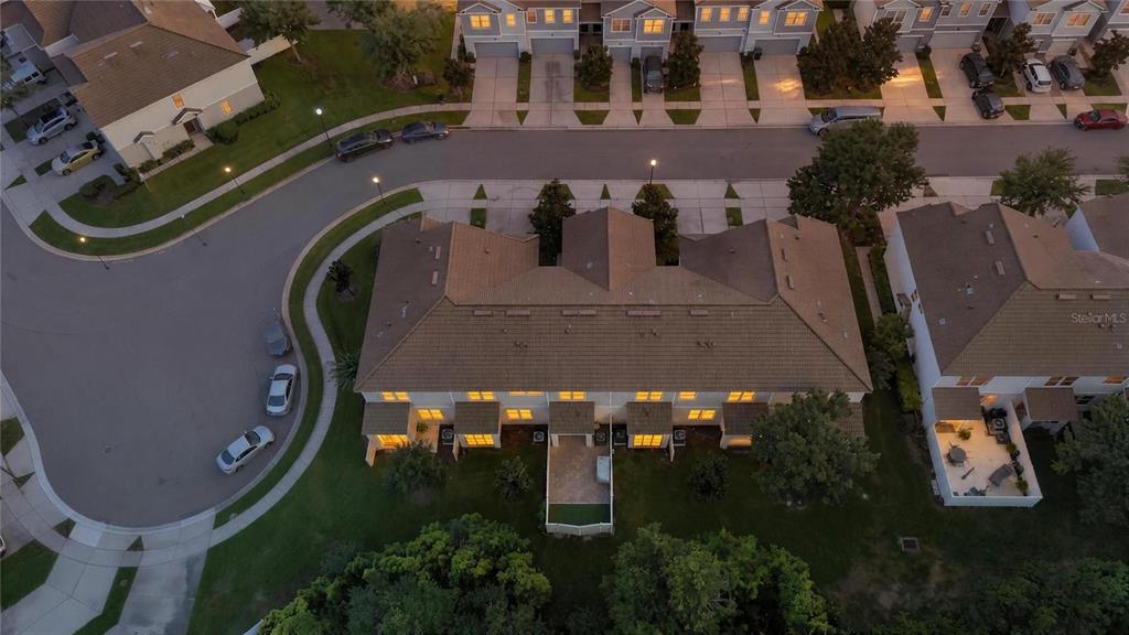An aerial view shows a multi-unit townhouse complex with a tiled roof and paved driveways — 9217 SHEPTON STREET, ORLANDO, FL
