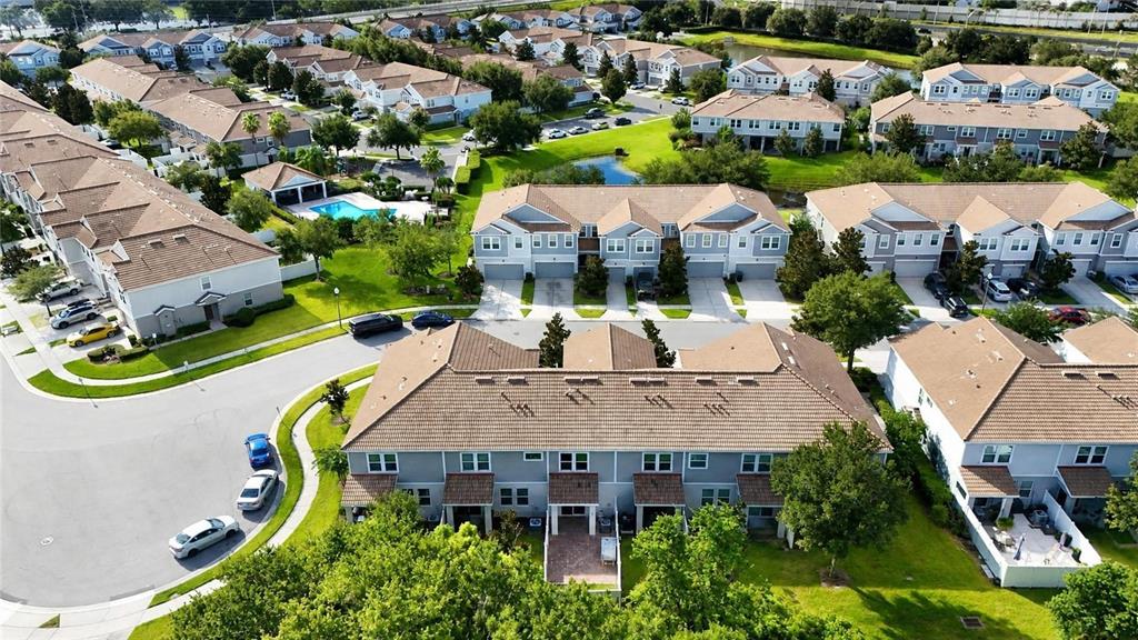 An aerial view shows multiple rows of suburban townhomes with tan roofs and green lawns — 9217 SHEPTON STREET, ORLANDO, FL