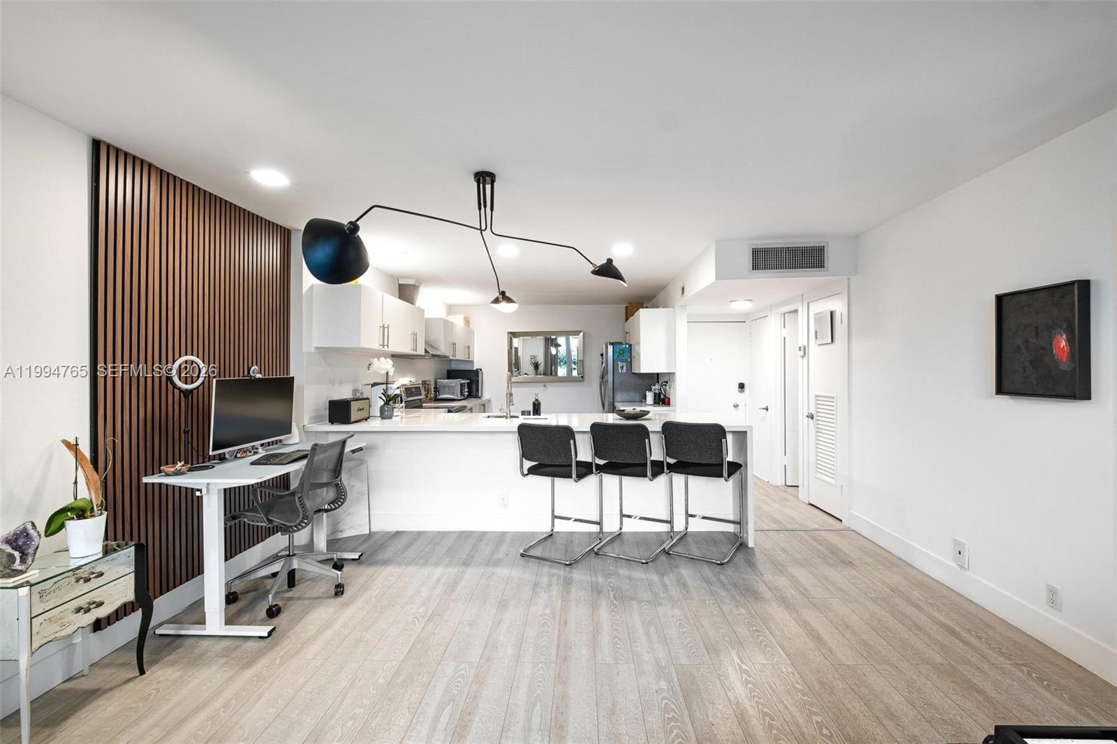 A modern kitchen and home office area feature wood-slat wall paneling and light wood flooring — 5 Island Ave, Miami Beach FL 33139, MIAMI BEACH, FL