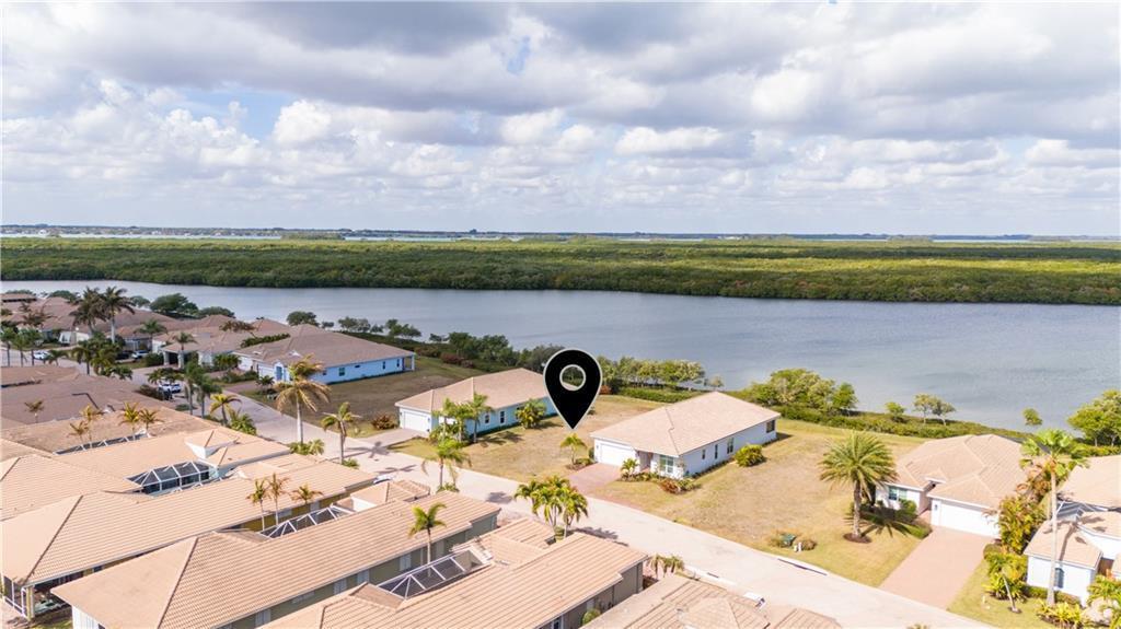 An aerial view shows suburban houses with tile roofs situated along a waterfront — HUTCHINSON ISLAND, FL