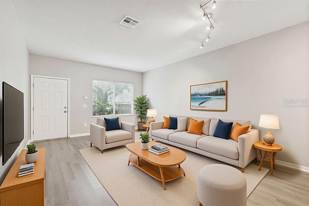 A living room features light gray flooring, a beige sofa, and a wooden coffee table — 18214 PARADISE POINT DRIVE, TAMPA, FL