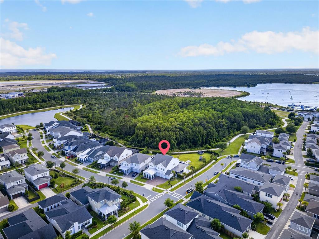 An aerial view shows a residential neighborhood with a red pin marking a specific house — 14406 HAROCHE AVENUE, ORLANDO, FL