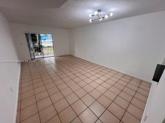 An empty room features light-colored square floor tiles, white walls, and a modern ceiling light — 2690 W 76th St # 106, Hialeah FL 33016, HIALEAH, FL