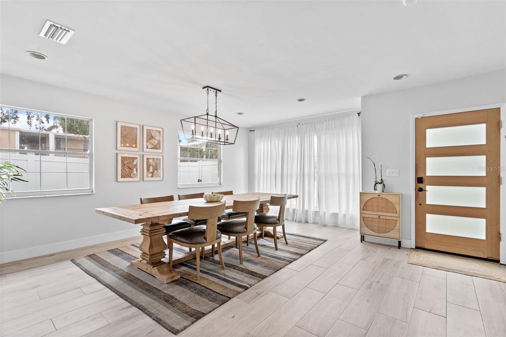 A dining room features a wooden table, chairs, a striped rug, and a front door — 3601 W DALE AVENUE, TAMPA, FL