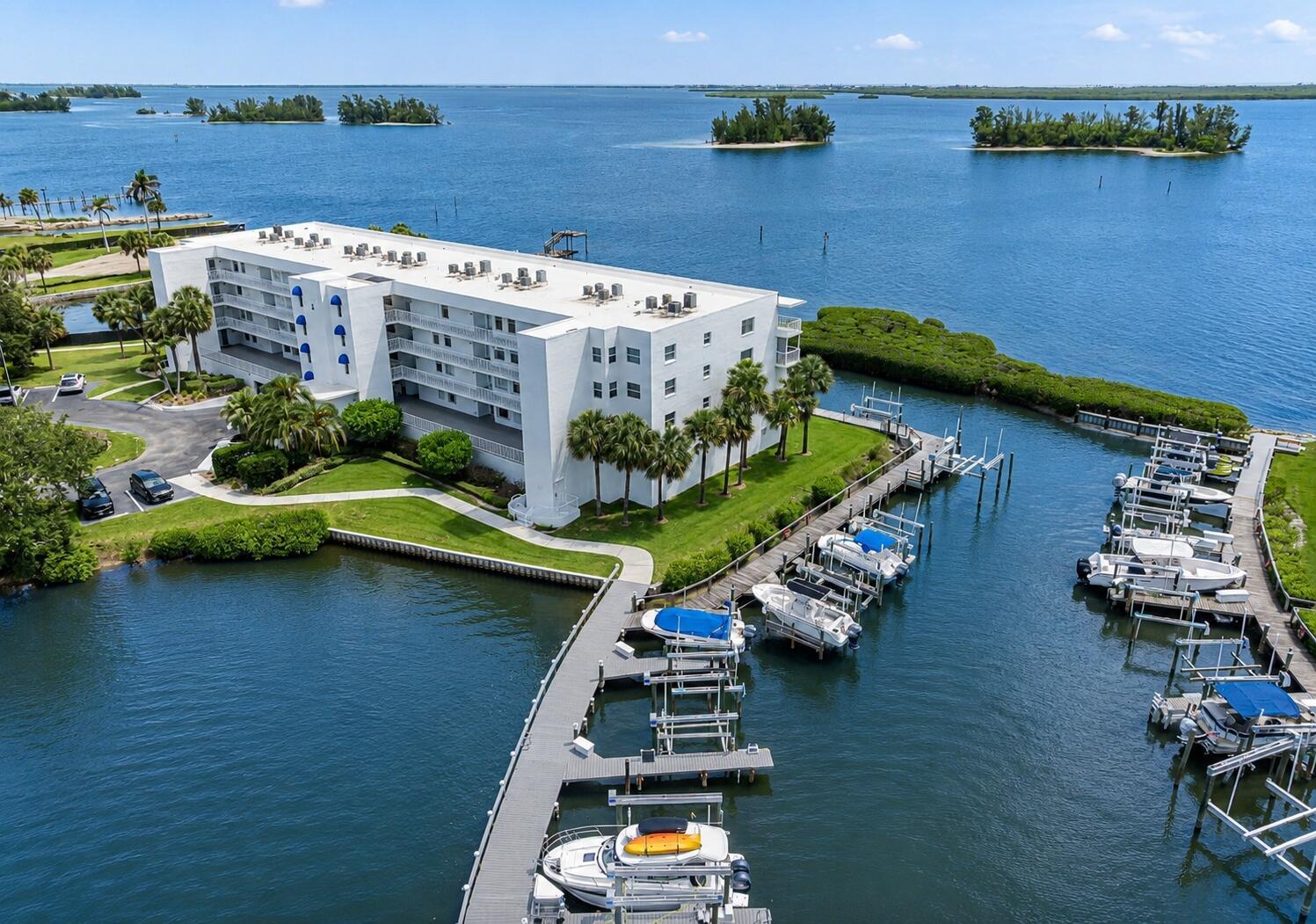An aerial view shows a white multi-story apartment building next to a boat dock — 6005 River Run Drive, Sebastian FL 32958, SEBASTIAN, FL