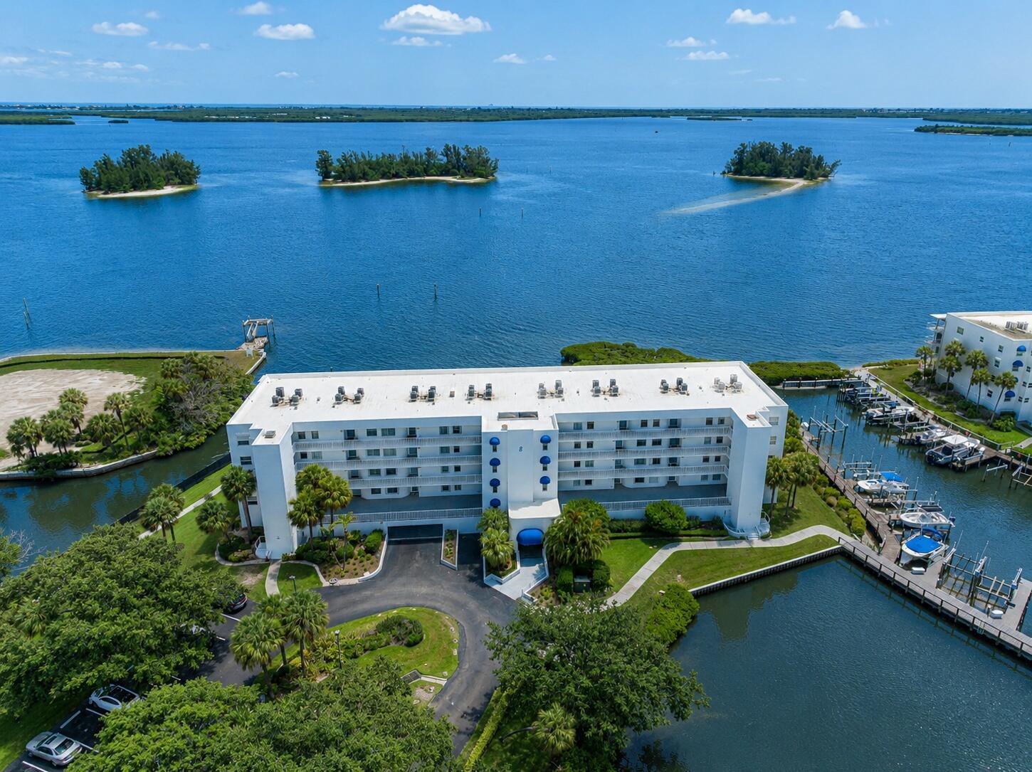 An aerial view of a white multi-story apartment building situated on a waterfront property — 6005 River Run Drive, Sebastian FL 32958, SEBASTIAN, FL
