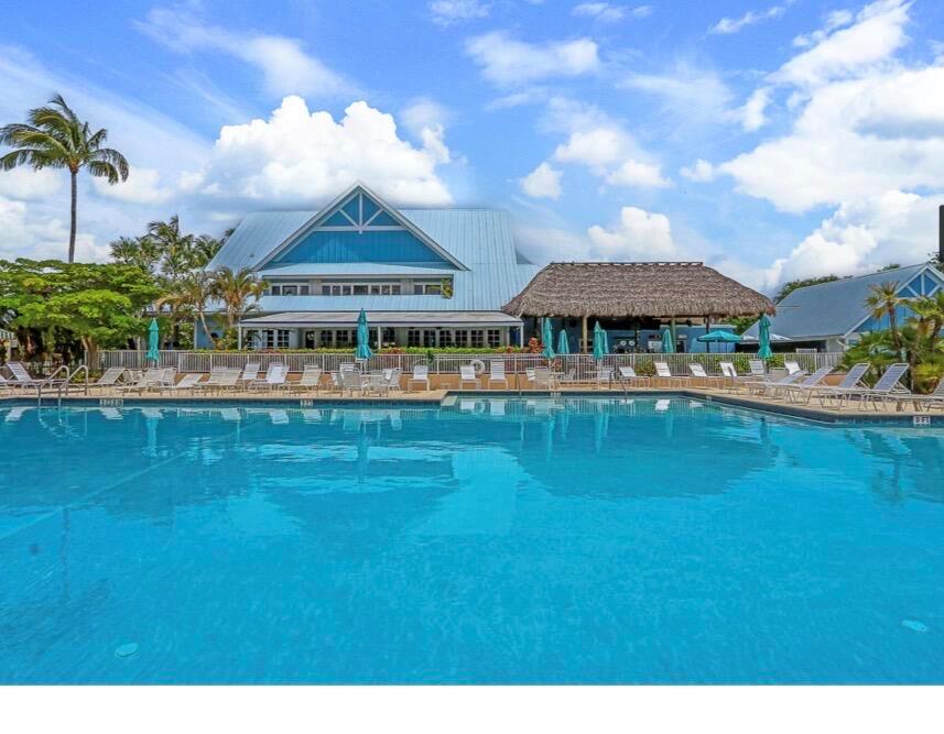A swimming pool sits in front of a large building with a blue roof — 353 S Us Highway 1 # A207, Jupiter FL 33477, JUPITER, FL