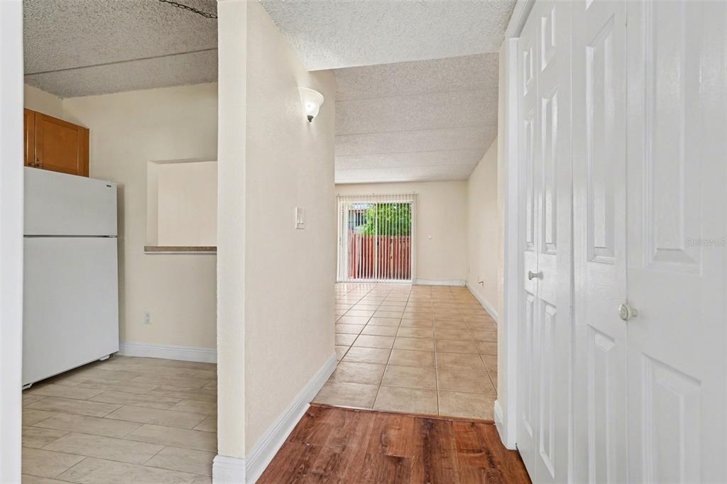 A view from an entryway looking toward a kitchen, living area, and sliding glass doors — 2845 SOMERSET PARK DRIVE UNIT 101, TAMPA, FL