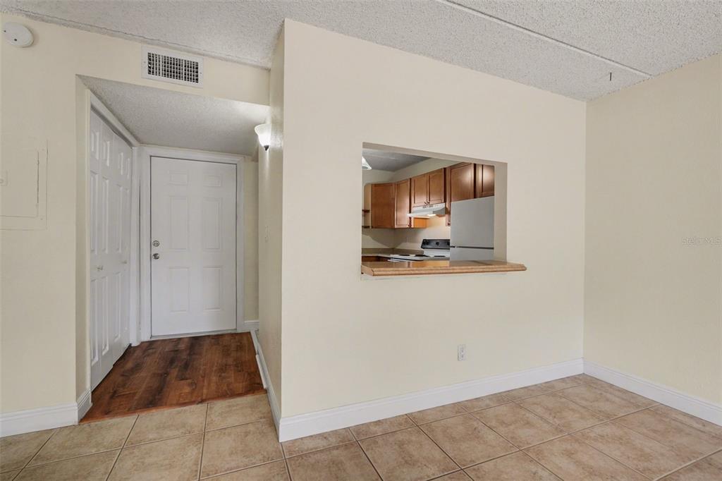 A view of an entryway with wood flooring and a kitchen pass-through window — 2845 SOMERSET PARK DRIVE UNIT 101, TAMPA, FL