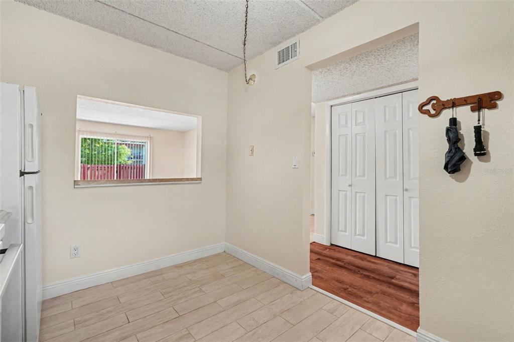 A dining area with light tile flooring, a pass-through window, and a white refrigerator — 2845 SOMERSET PARK DRIVE UNIT 101, TAMPA, FL
