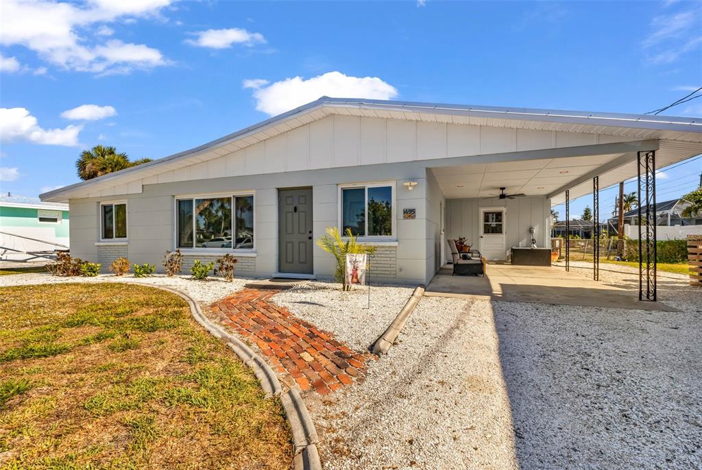 A single-story house with a gray exterior, a brick walkway, and a covered carport — 1495 S MARYKNOLL ROAD, ENGLEWOOD, FL