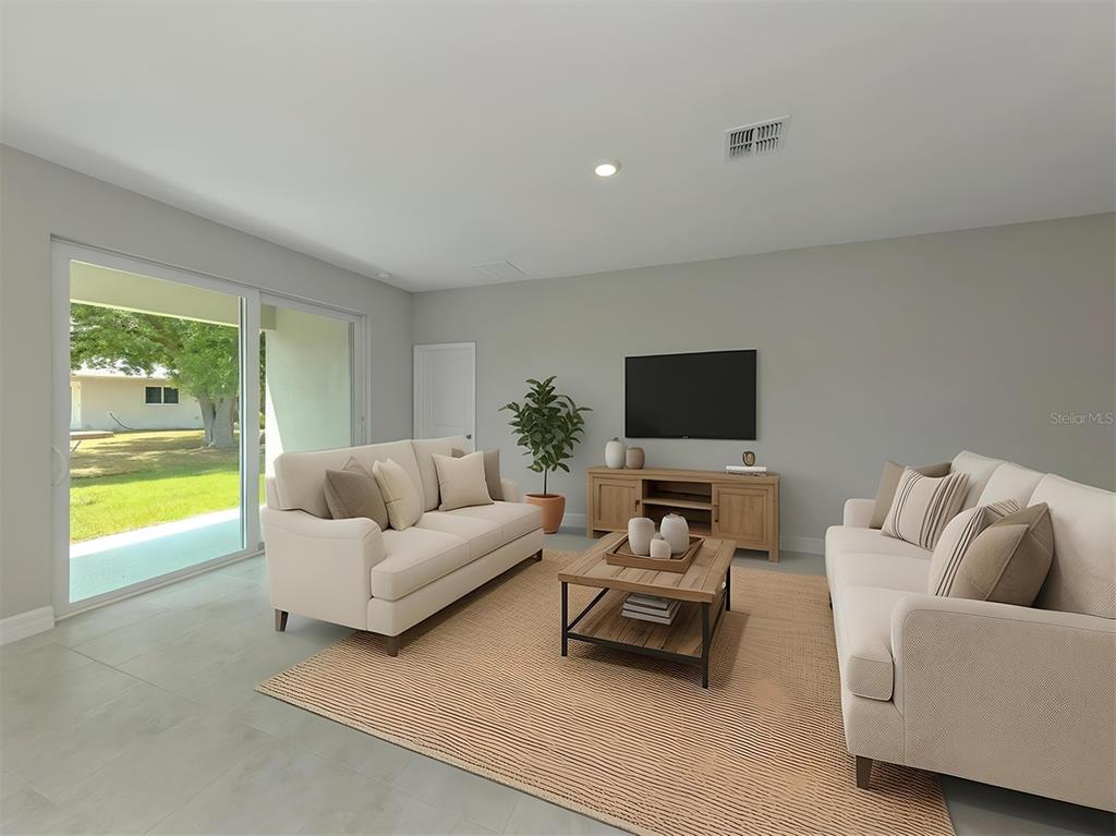 A living room features two beige sofas, a wooden coffee table, and a sliding glass door — 1047 COMFORT LANE, NORTH PORT, FL