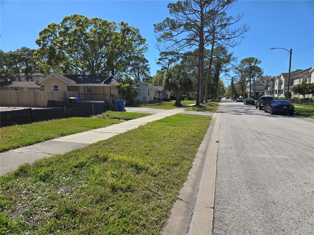 A street view shows a sidewalk, a grassy verge, and several houses under a clear sky — 134 49TH AVENUE N, ST PETERSBURG, FL
