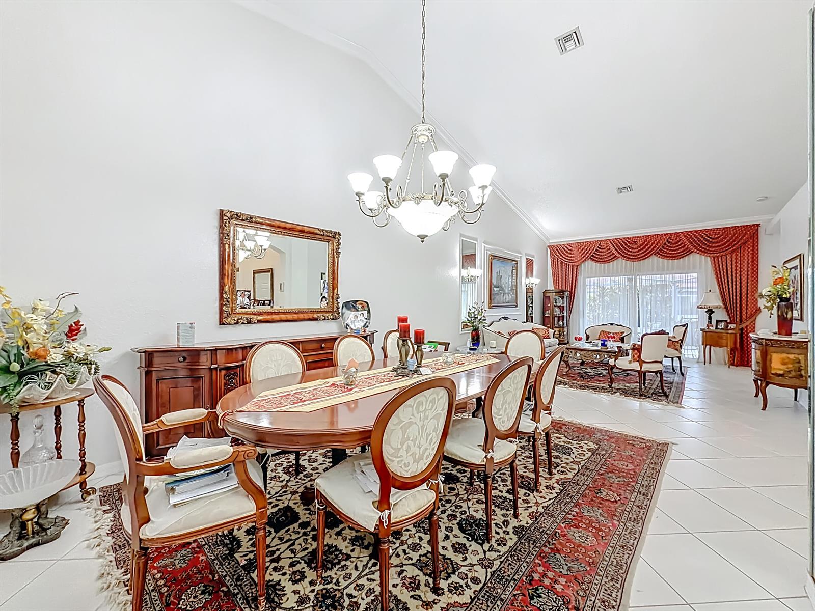 A formal dining room features a wooden table, upholstered chairs, and a large chandelier — 6174 Caladium Road, Delray Beach FL 33484, DELRAY BEACH, FL