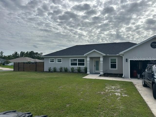 A single-story house with a gray exterior, dark roof, and an attached garage — 12942 SW 70TH TERRACE, OCALA, FL