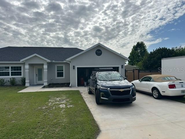 A single-story house with a gray exterior, a two-car garage, and two vehicles parked outside — 12942 SW 70TH TERRACE, OCALA, FL