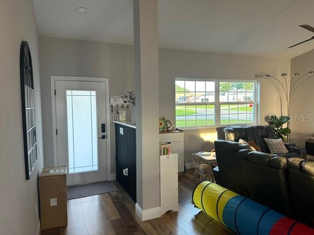 An entryway with a white door leads into a living room with wood-look flooring — 12942 SW 70TH TERRACE, OCALA, FL