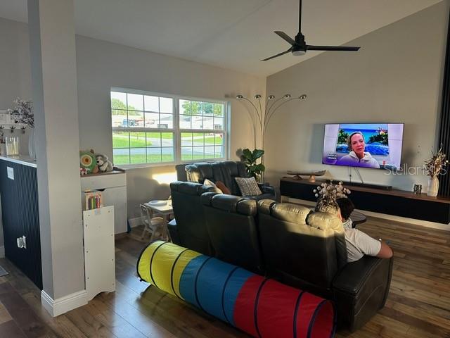 A living room with a dark leather sofa, a ceiling fan, and a wall-mounted television — 12942 SW 70TH TERRACE, OCALA, FL