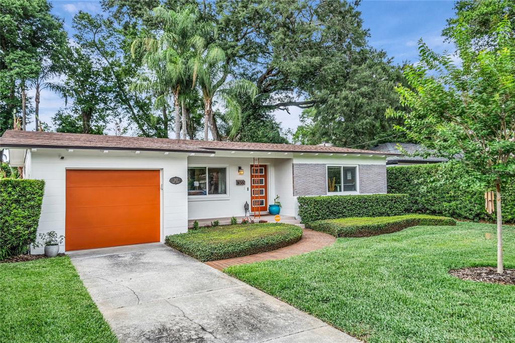 A single-story house with a white exterior, orange garage door, and a matching orange front door — 303 E JERSEY STREET, ORLANDO, FL