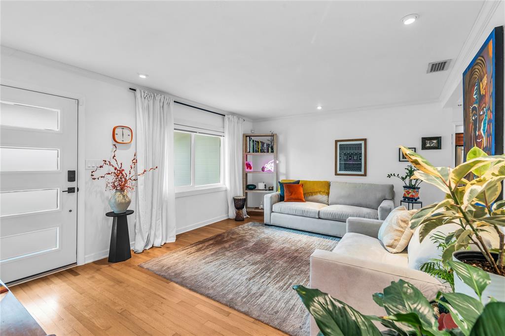 A living room features light hardwood floors, a gray sofa, and a large area rug — 303 E JERSEY STREET, ORLANDO, FL