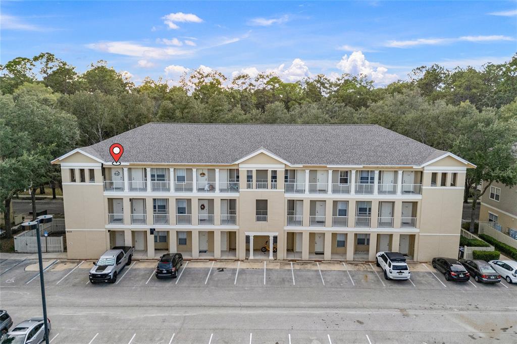 An exterior view of a three-story apartment building with a parking lot in front — 5133 SW 91ST CT. COURT UNIT G304, GAINESVILLE, FL