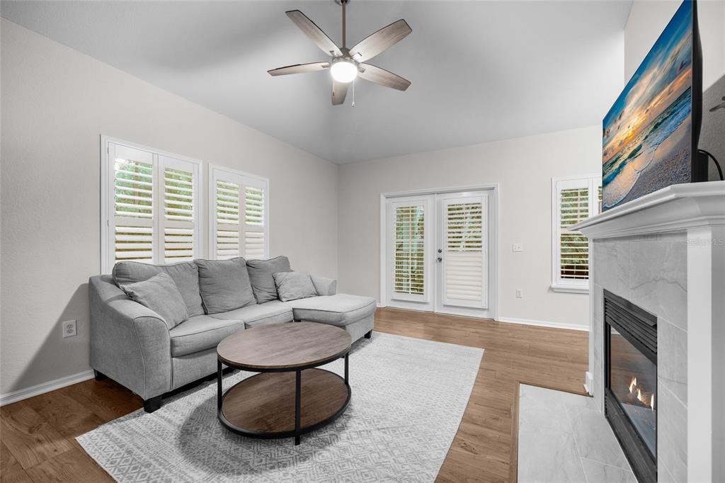 A living room features a gray sectional sofa, a round coffee table, and a fireplace — 5133 SW 91ST CT. COURT UNIT G304, GAINESVILLE, FL